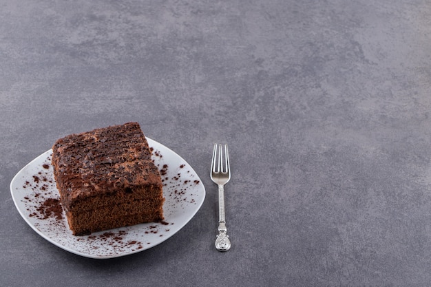 White plate of sweet sliced cake on stone table.