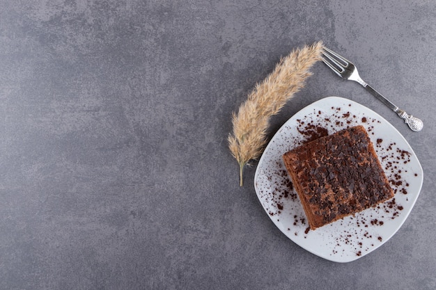 White plate of sweet sliced cake on stone table.