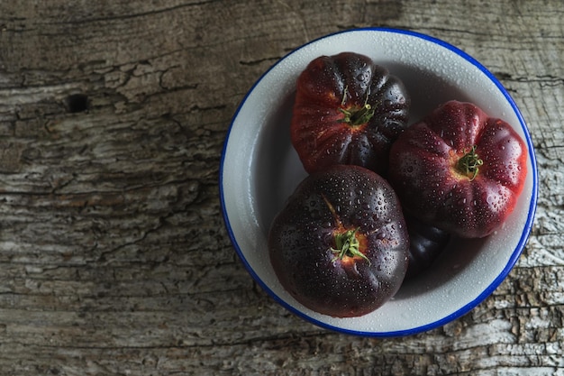 Photo white plate with blue sea tomatoes on old wood background copy space top view