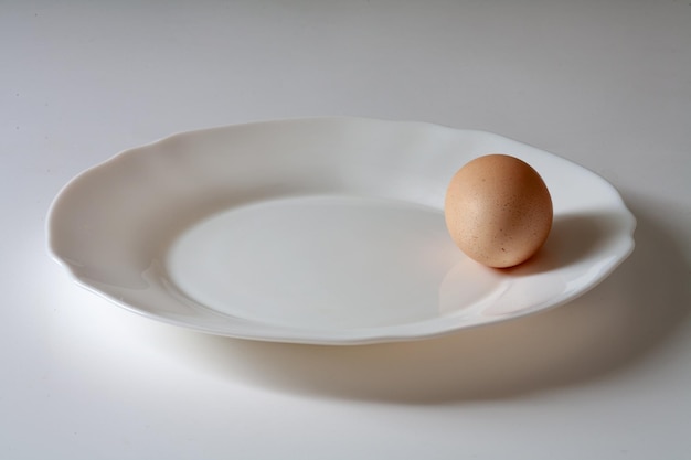 A white plate with a brown egg on it