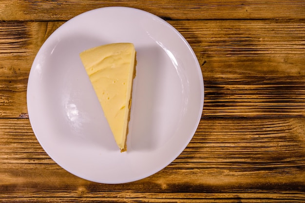 소박한 나무 테이블에 치즈 케이크 뉴욕이 있는 흰색 접시. 평면도
