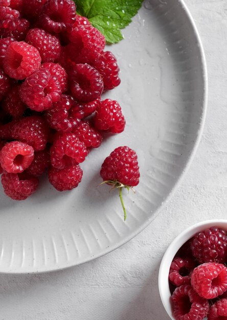 White plate with fresh rasberries. Top view food.