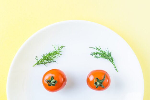 White plate with small tomatoes and dill. 