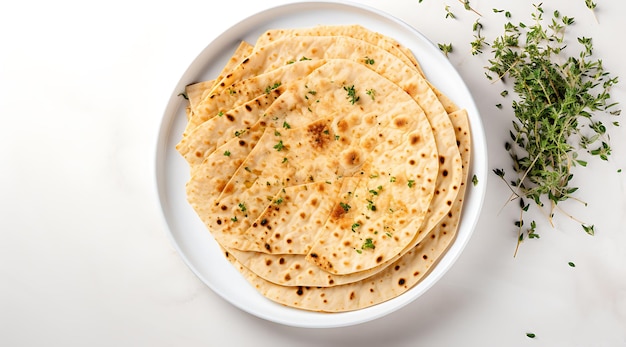 a white plate with tortillas on it and a white plate with a green leaf on it