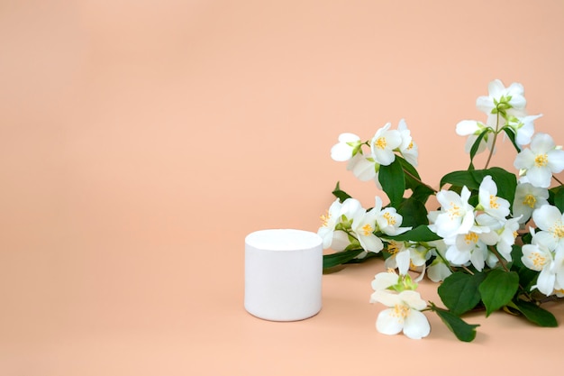 Photo white podium for displaying cosmetics and various products on a beige background with jasmine close up