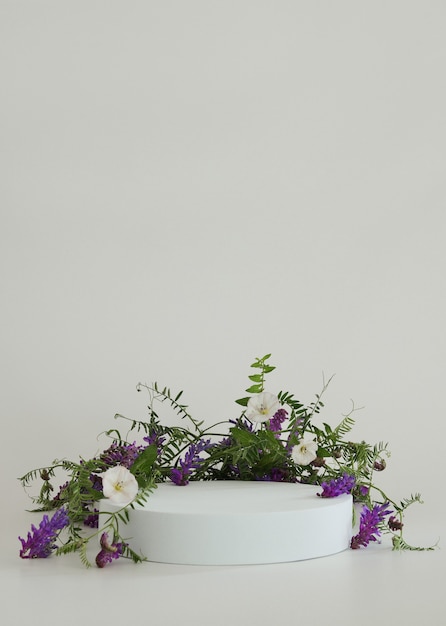 White podium on the white background with flowers Podium for product cosmetic presentation