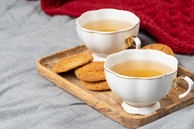 White porcelain cup of tea and oat cookies on a table