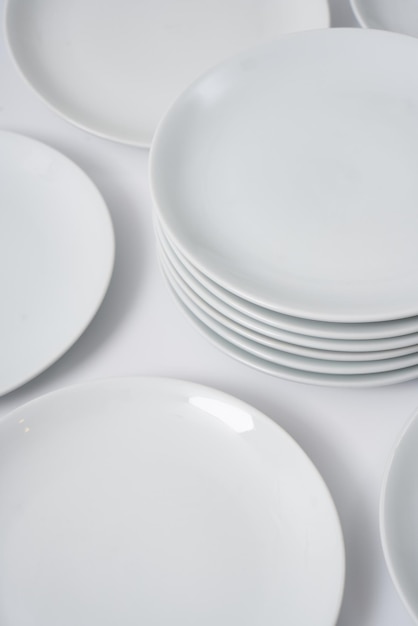 White porcelain plates and coffee cups on a white background