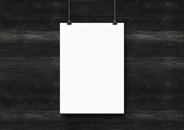 写真 クリップ付きの黒い木製の壁に掛かっている白いポスター