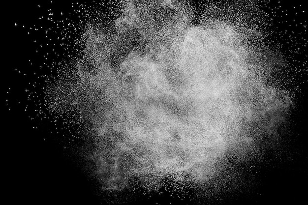 White powder dust particles explosion on a black background.