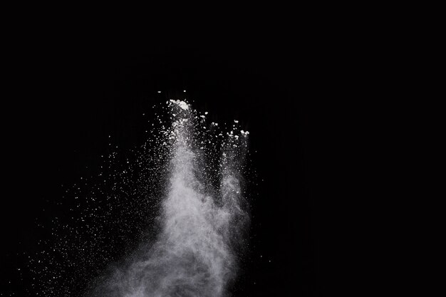 White powder explosion on black background. Colored cloud. Colorful dust explode. 