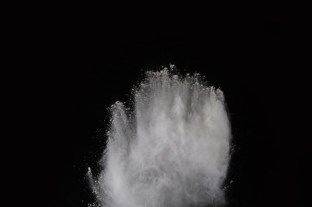 White powder explosion on black background. Colored cloud. Colorful dust explode. 