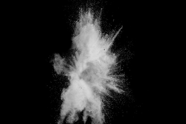 Взрыв белого порошка изолированный на черной предпосылке. Брызги частиц белой пыли