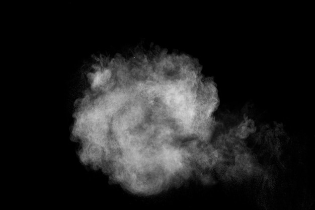 Esplosione di polvere bianca isolato su priorità bassa nera. spruzzata di particelle di polvere bianca.