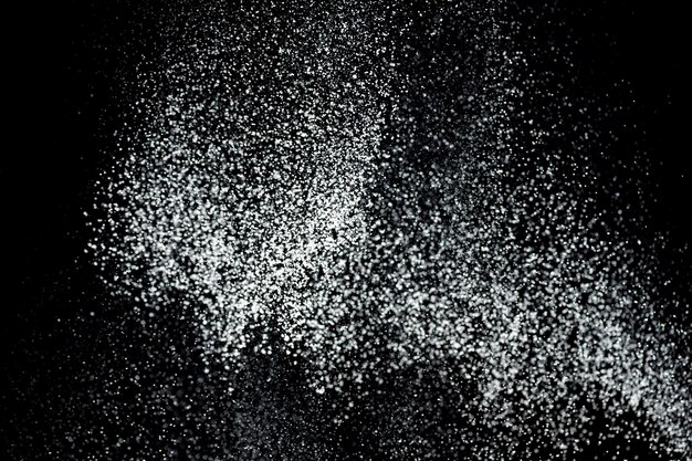 Foto esplosione di polvere bianca spruzzo di polvere bianca isolato su sfondo nero setaccio di farina su sfondo scuro polvere esplosiva bianca