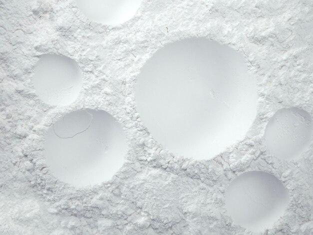 White powder surface with cracks and a round crater