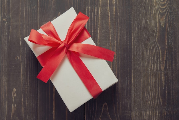 Photo white present box on dark wooden table. happy birthday