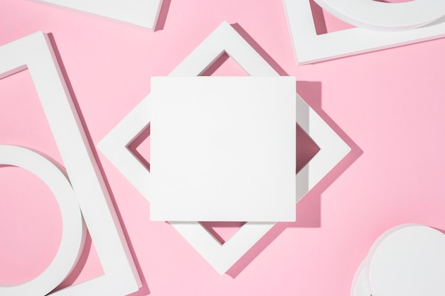 White presentation podiums geometric shapes on a pink background. Top view, flat lay.