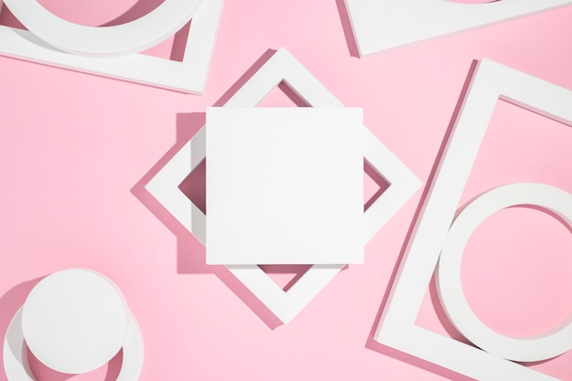 White presentation podiums geometric shapes on a pink background. Top view, flat lay.