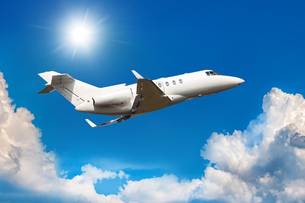 White private jet flies in the air above the clouds