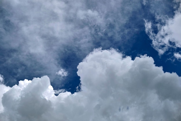 White puffy cumulus clouds on summer blue sky