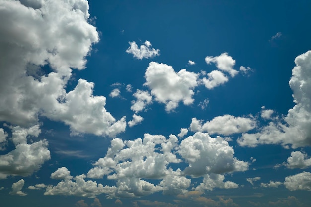 White puffy cumulus clouds on summer blue sky