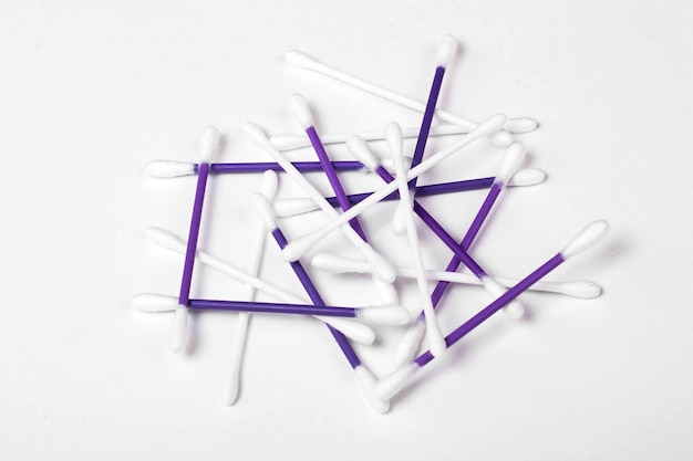 White and purple cotton buds on white background