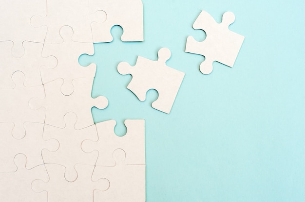 White puzzle background with missing piece on blue background.