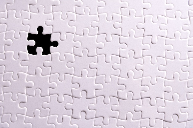 Photo white puzzle and one missing puzzle piece.