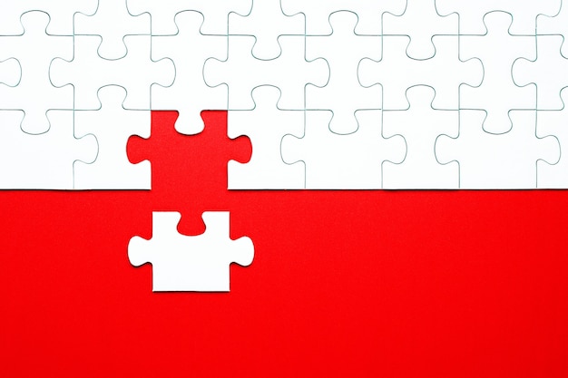 Pezzi del puzzle bianco su uno sfondo rosso separato