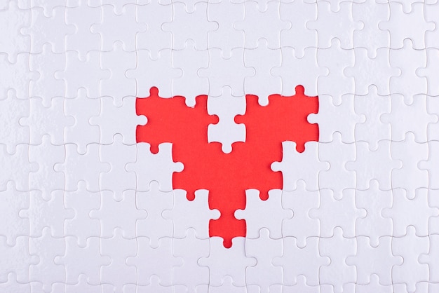 Photo white puzzle pieces and red background above view