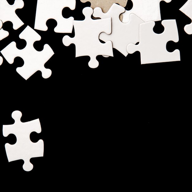 Photo white puzzles on black surface