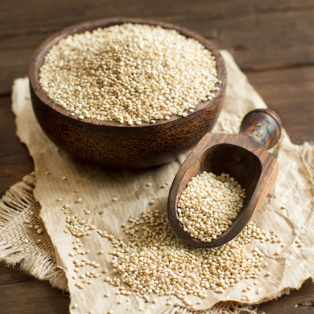 White Quinoa in a bowl with a wooden spoon close up