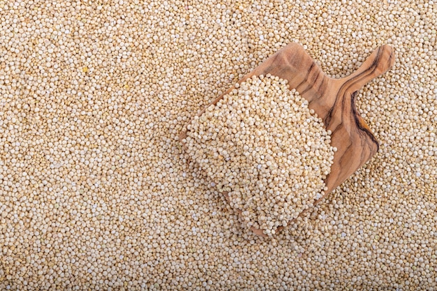 Foto superficie bianca della quinoa con un cucchiaio di legno, primo piano