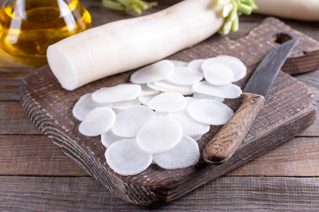 White radish sliced on wooden table. Daikon radish