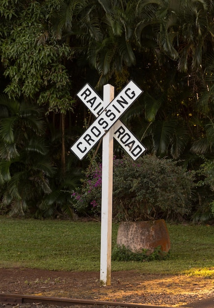 Photo white railroad crossing sign at sunset