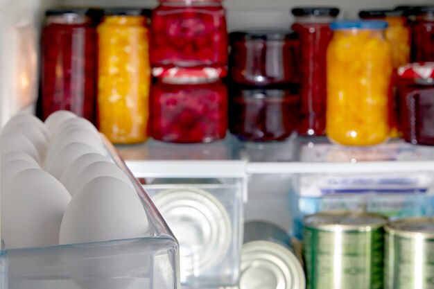 White raw chicken eggs in a tray of the refrigerator on the background of food products Egg day Selective focus