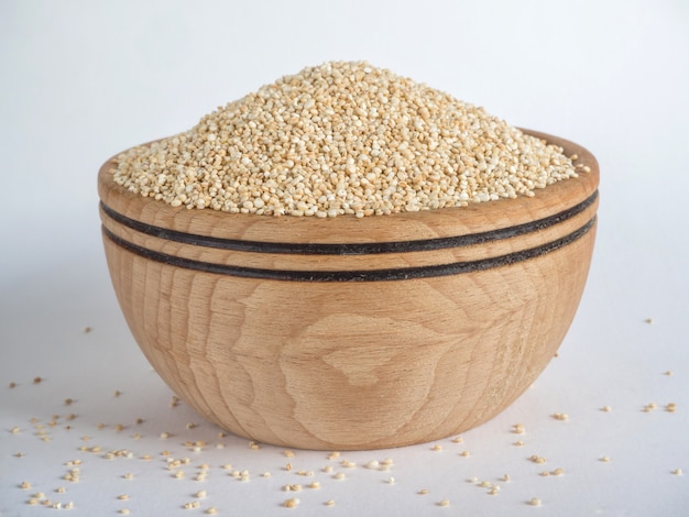 White raw quinoa in a wooden bowl.