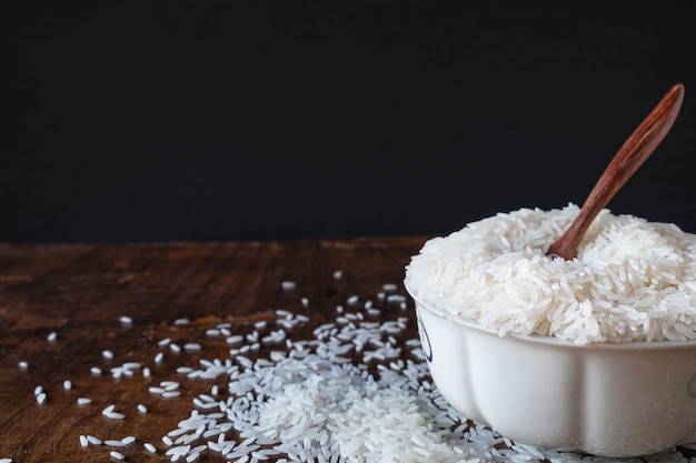 White raw rice in a bowl on a wooden table