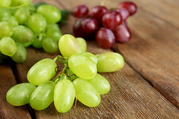 Белый и красный виноград на деревянном фоне