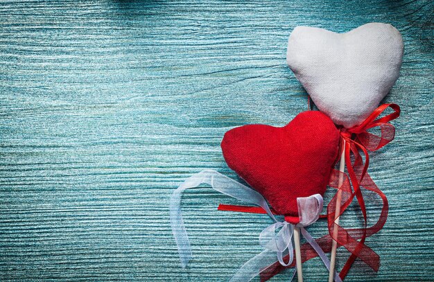 White red hearts with ribbons on wooden board holidays concept