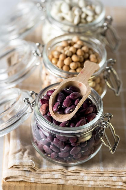 White and Red Lentils and Chickpeas in Glass Jars on Napkin Vertical