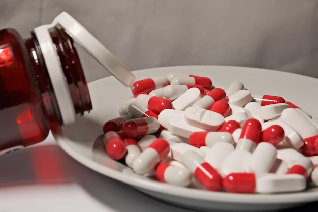 White and red pills in a plate closeup the concept of health treatment