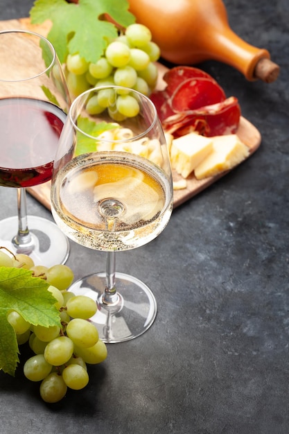 White and red wine glasses grape and appetizer board