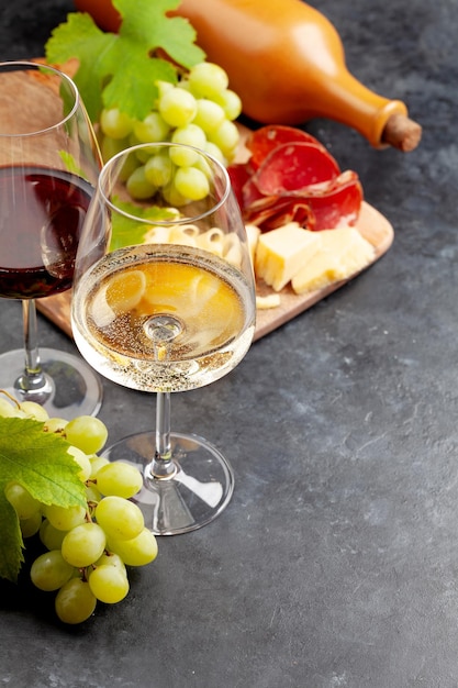 Bicchieri da vino bianco e rosso uva e bordo di antipasti