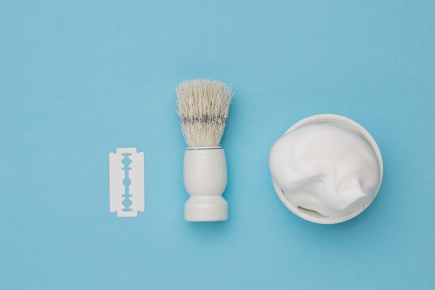 White retro shaving accessories on a blue surface