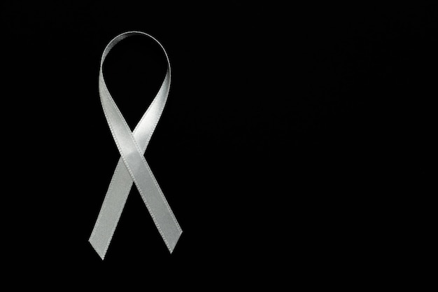 White ribbon on black background symbol of peace and protest against violence against women