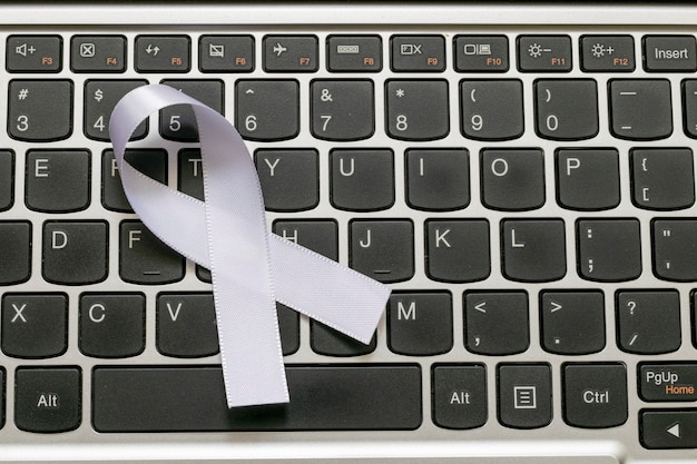 컴퓨터 키보드의 흰색 리본은 정신 건강 프로그램을 나타냅니다.