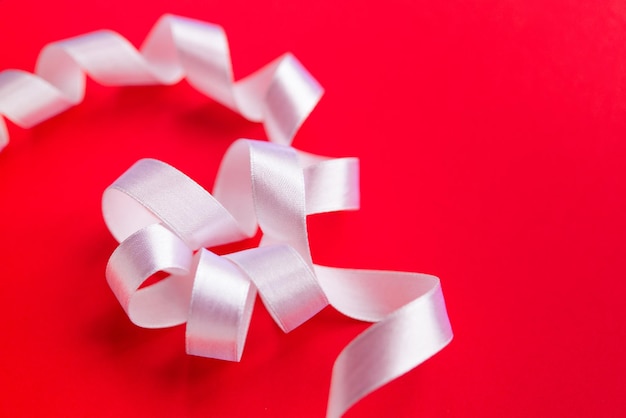 White ribbon with bow on a red