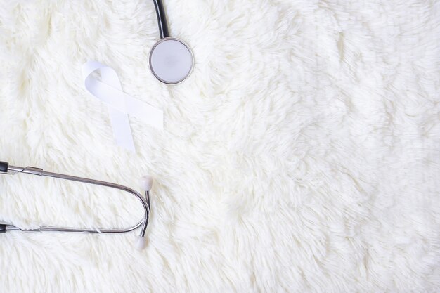 White Ribbon with stethoscope on white color background. November Lung Cancer Awareness month concept